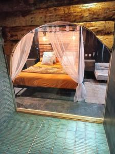 Posto letto in camera con rete di La Cachette des Tisserands, Hammam, Balneo a Pontivy