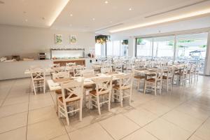 a dining room with white tables and chairs at Gaia Sun N Blue Hotel in Ayia Napa