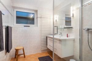 un bagno bianco con lavandino e doccia di Am Alpenblick 5 a Lindau Altre 14 foto