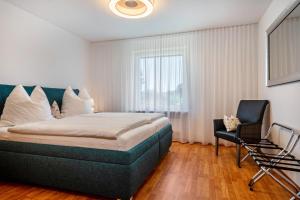 una camera da letto con un letto grande e una sedia di Am Alpenblick 5 a Lindau