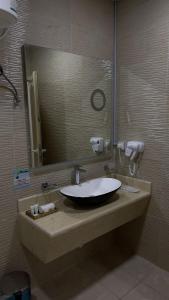 a bathroom with a sink with a large mirror at بيت خزامى للشقق الفندقية المخدومة in Najran