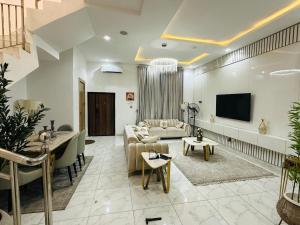 a living room with a couch and a tv at SamKash Home in Mama