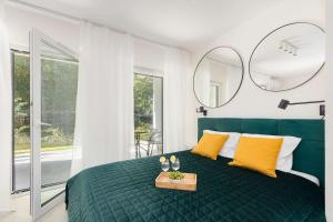 une chambre avec un lit vert avec des oreillers jaunes dans l'établissement Bright Studio with Terrace and Parking Close to the Sea in Niechorze by Noclegi Renters, à Niechorze