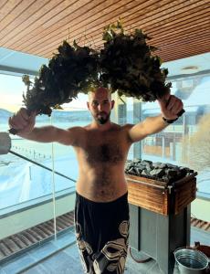 HolmsbuHolmsbu Resort的一个赤裸上身的男人手里拿着一束绿色蔬菜