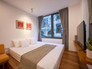 a bedroom with a bed and a tv and a window at DIAMOND Matrix One in Heart of District 1-Luxury Living-Coffee Shop Above in Ho Chi Minh City