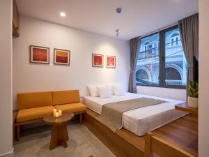 a bedroom with a bed and a couch and a window at DIAMOND Matrix One in Heart of District 1-Luxury Living-Coffee Shop Above in Ho Chi Minh City