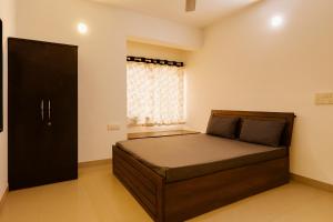 una camera da letto con un letto e una finestra di ll COCKTAIL VILLA ll 3BHK ll AC ll PRIVATE POOL ll a Lonavala