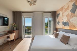 a bedroom with a large bed and a desk and window at Openhouse Stay in Fano +27 photos