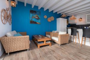 ein Wohnzimmer mit blauen Wänden und Stühlen sowie einem Tisch in der Unterkunft La Maison bleue Domainedecolomban in Carnac + 17 Fotos