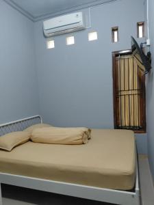 a small bed in a room with at IB Homestay Syariah by Ecommerceloka in Tegal