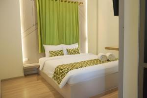 a bedroom with a bed with a green curtain at Sukun Hotel Cilacap in Cilacap