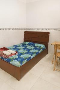 a bed in a room with a table and chairs at Phương Vy Motel in Phước Bình
