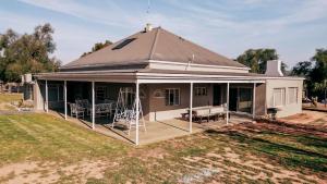 una casa con un gran porche con techo en Shama Guest Farm - A True Klein Karoo Farm Escape, en Oudtshoorn