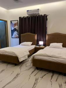 een slaapkamer met 2 bedden en airconditioning bij ASNB Residences-F4 in Multan