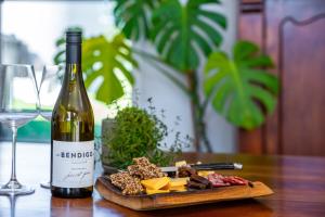 a bottle of wine and a plate of cheese and meats at 2BR Guest Retreat in Country Home with Shared Hallway in Tarras +30 photos