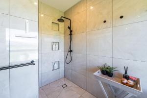 a shower with a glass door in a bathroom at 2BR Guest Retreat in Country Home with Shared Hallway in Tarras