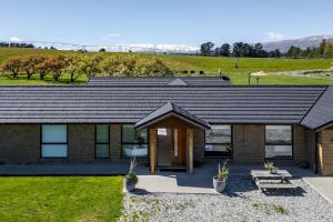 a brick house with a table and benches in front of it at 2BR Guest Retreat in Country Home with Shared Hallway in Tarras