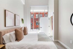 a bedroom with a large bed with white sheets at Spacious 2BR CozySuites OTR Downtown #12 in Cincinnati