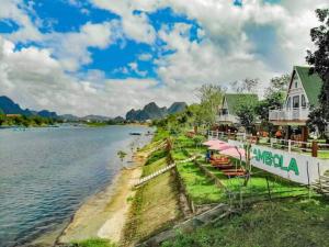 a resort on the shore of a body of water at Carambola Lodge in Phong Nha