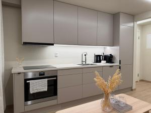 a kitchen with white cabinets and a sink at Parkside apartment in Narvik