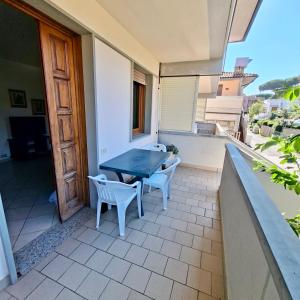 a patio with a table and chairs on a balcony at ISA - Felci 19, apartment 6 beds in Marina di Bibbona just 300 mt from the sea in Marina di Bibbona
