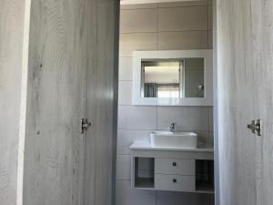 un baño con lavabo y espejo en Swem Jannie, en Struisbaai 14 fotos más