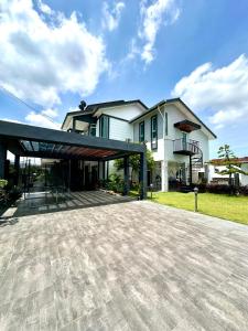 a large white house with a large driveway at Stylish Villa Alma 18 Guests - Pool, KTV & BBQ in Simpang Ampat
