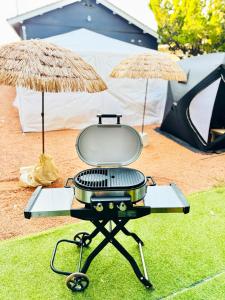 a grill on a table with two umbrellas at Ocean House NUI in Katakai