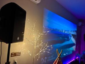 a tv screen with a tree projected on a wall at Ocean House NUI in Katakai +75 photos