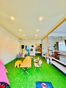 a room with a green floor with a table and chairs at Ocean House NUI in Katakai +75 photos