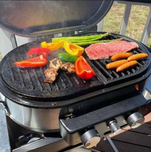 a steak and vegetables are cooking on a grill at Ocean House NUI in Katakai
