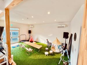 a room with green grass and a room with tents at Ocean House NUI in Katakai