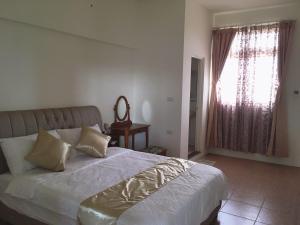 a bedroom with a large bed and a window at 白宮七哩香園民宿 in Hou-p'an-ts'un +3 photos