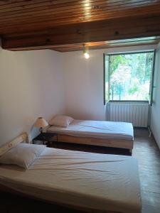 two beds in a room with a window at Maison Ancienne Albies in Albiès