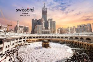una gran multitud de personas en una ciudad con una torre de reloj en Swissotel Makkah, en La Meca