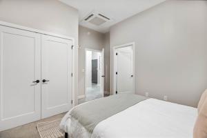 a white bedroom with a bed and white cabinets at Spacious 2BR CozySuites OTR Downtown #10 in Cincinnati