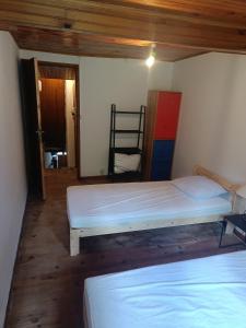 a room with two beds and a chair in it at Maison Ancienne Albies in Albiès