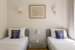 two beds sitting next to each other in a room at Royal Hideaway Estoril 2BR Pool Retreat in Estoril