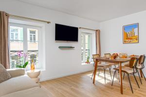 a living room with a table and a tv at FELIX FAURE - Somptueux 3 pièces - Carré d'Or Menton - PARKING in Menton