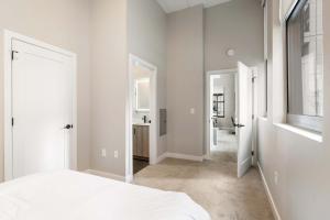 una camera da letto bianca con un letto e un bagno di Spacious 2BR CozySuites OTR Downtown #14 a Cincinnati