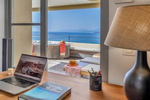 a laptop on a desk with a view of the ocean at Maison de pêcheur dans le Cap Corse in Erbalunga