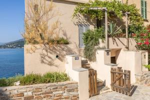 a house by the water with a wooden door at Maison de pêcheur dans le Cap Corse in Erbalunga +40 photos