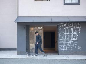 Un uomo che porta a spasso un cane davanti a un palazzo di hotel anddoggy Kyoto Nijo a Kyoto