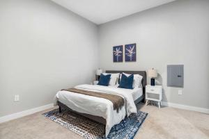 una camera da letto con un letto grande con cuscini blu di CozySuites Modern 3BR OTR District #18 a Cincinnati