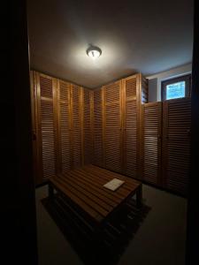 a room with a bench in a room with wooden shutters at Apartment Oganj in Jahorina +16 photos