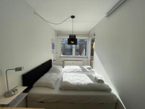 a bed in a small room with a window at Luxury City Stay Cozy Apartment with Sunny Balcony in Copenhagen
