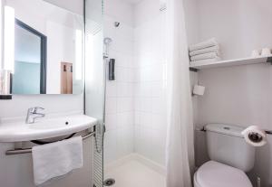 a white bathroom with a toilet and a sink at B&B HOTEL Annemasse Est in Annemasse
