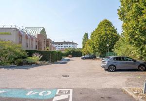 a parking lot with two cars parked in it at B&B HOTEL Annemasse Est in Annemasse +21 photos