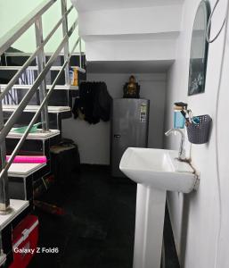 a bathroom with a sink next to a staircase at Shera farm in Khatauli