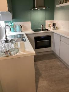 a kitchen with a sink and a stove top oven at Ground floor Appartment shared with host in Edinburgh +24 photos